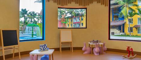 A room with large windows, a whiteboard, a table with a puzzle, and a rocking horse.
