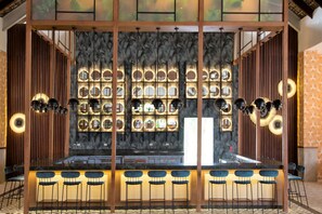 A bar area with a long counter and multiple stools. - Tropical Deluxe Princess - All Inclusive (Punta Cana)