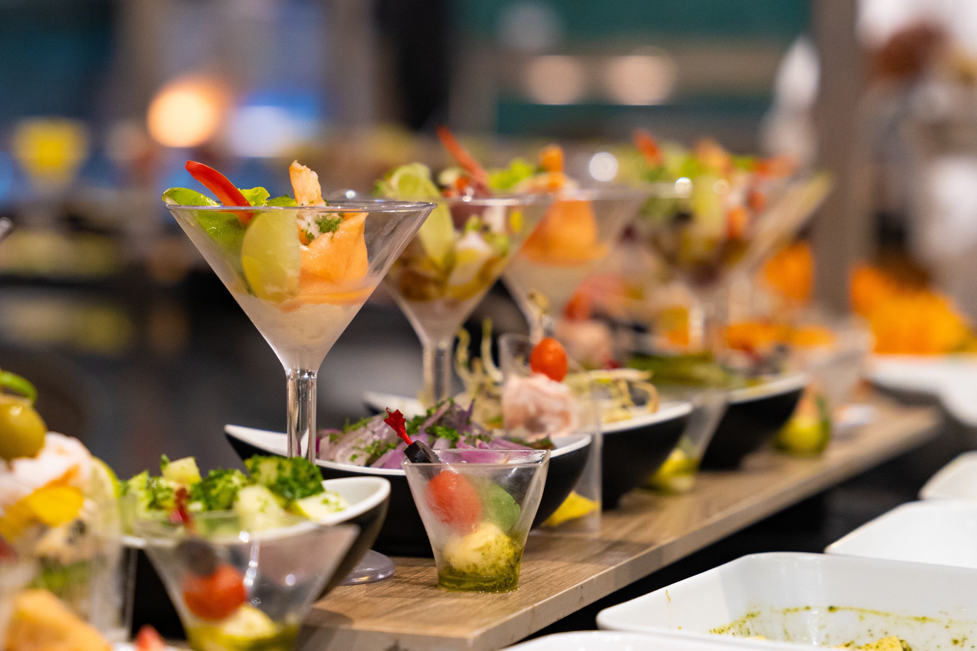 A variety of food items including salads and drinks in clear glasses.
