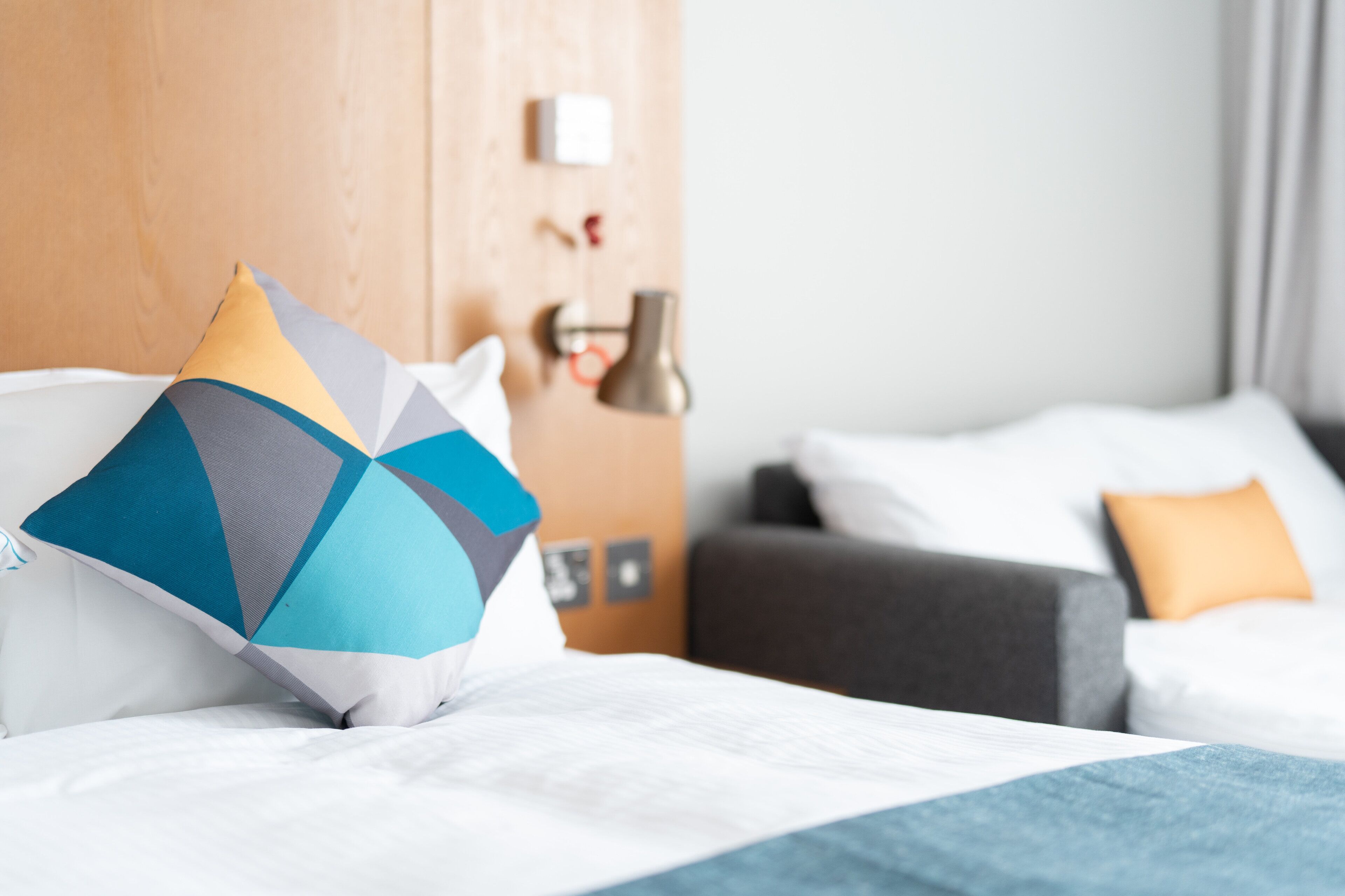 Una camera d'albergo con un letto, un divano e una lampada.