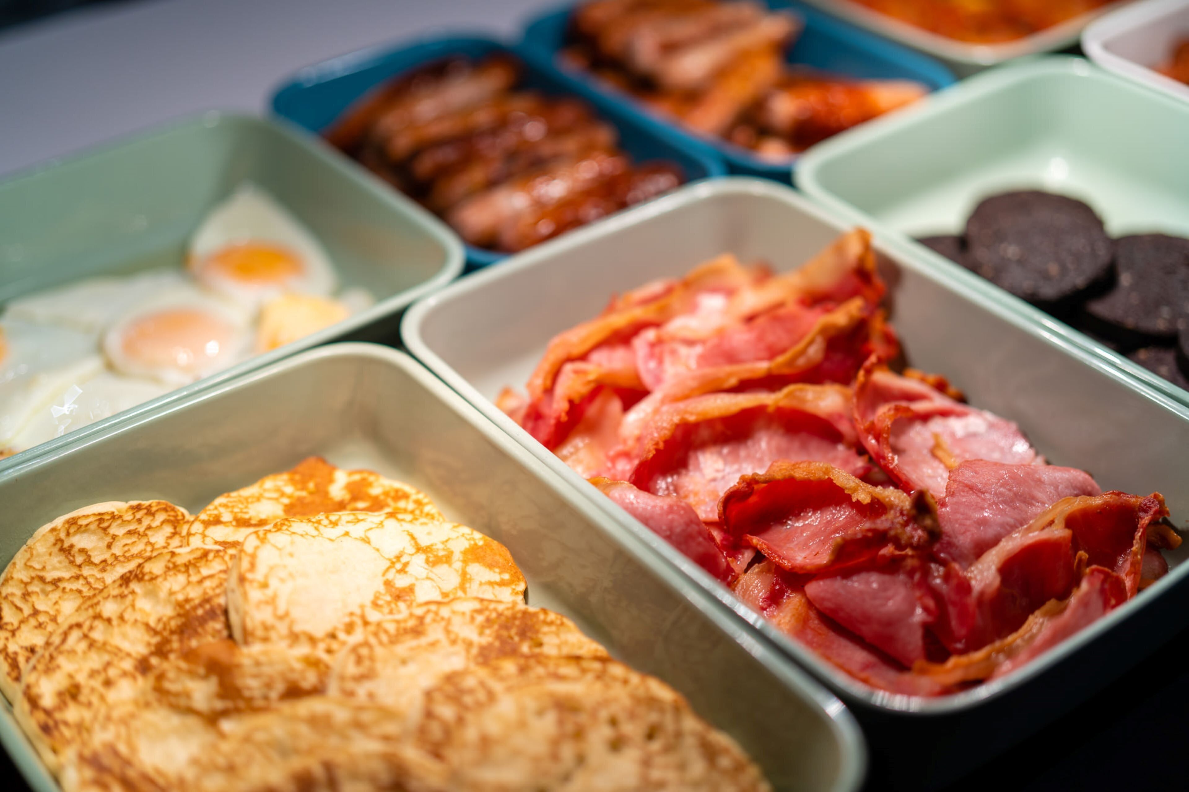 Un buffet de petit-déjeuner proposant une variété d’aliments, notamment des œufs, du bacon et des viennoiseries.