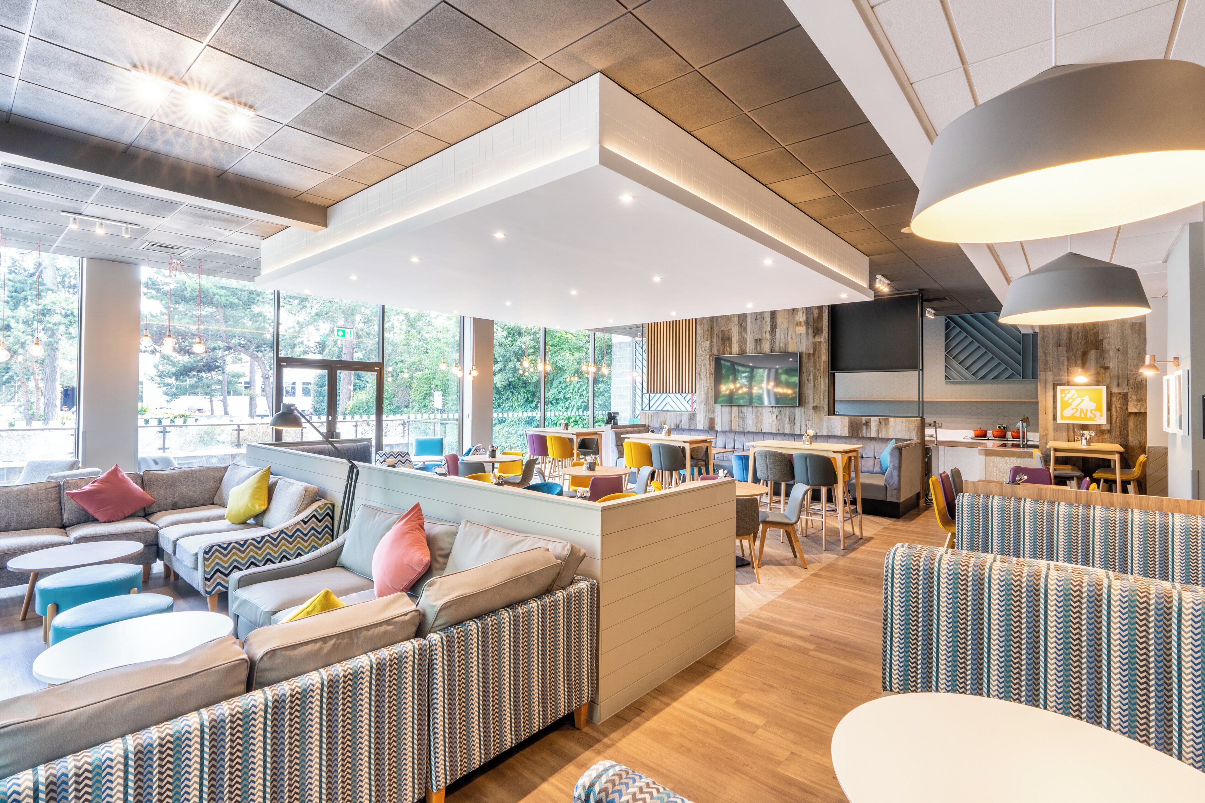 Un interior moderno con una zona de estar central, una cocina y ventanas amplias.