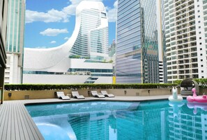 A rooftop pool with lounge chairs, surrounded by modern high-rise buildings. - Bliston Suwan Park View (Bangkok)