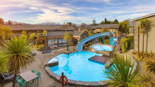A pool area with a slide, lounge chairs, and a lifebuoy. - Club Wyndham Wanaka, Trademark Collection by Wyndham (Wanaka)
