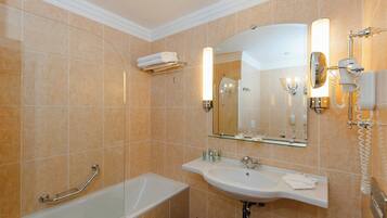 A bathroom with a bathtub, a sink, a mirror, and a towel rack.