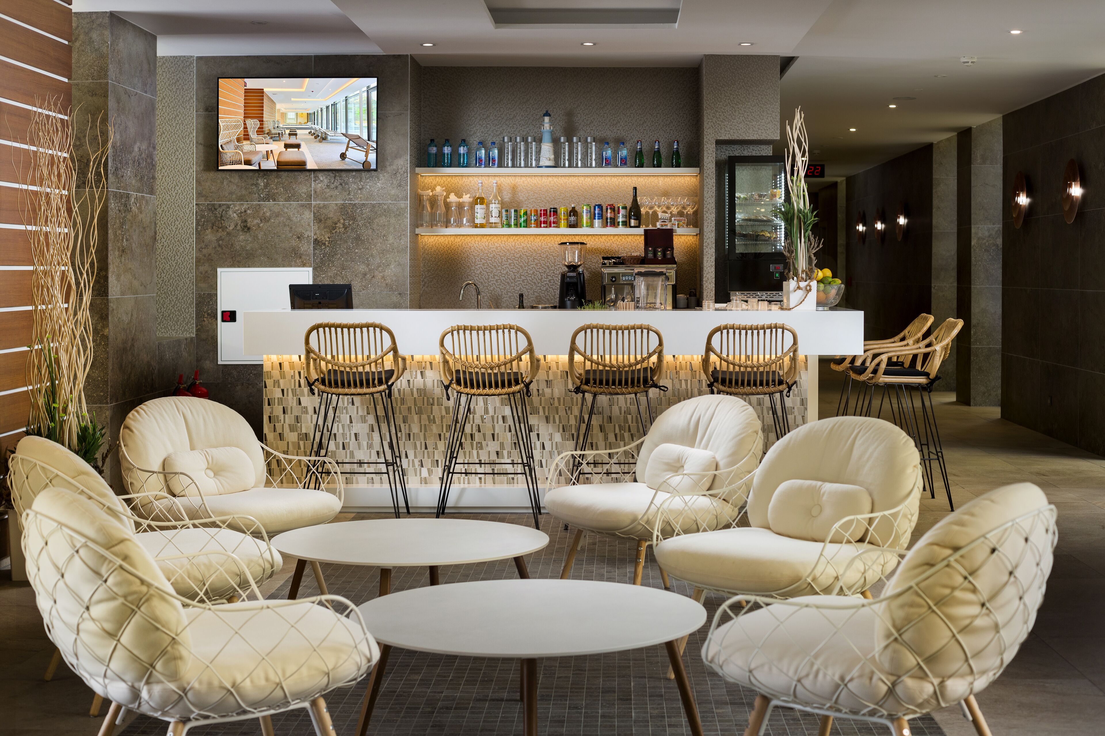 A modern bar area with seating and a TV screen.
