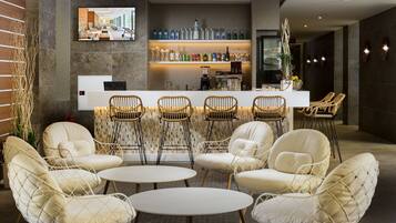 A modern bar area with seating and a TV screen.