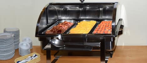 Un buffet proposant une variété de plats, notamment des viandes, des fromages et des œufs.