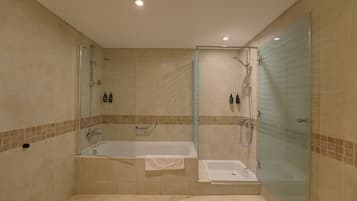 Une salle de bain moderne dotée d’une douche à parois de verre, d’une baignoire sur pied et d’une porte de douche en verre.
