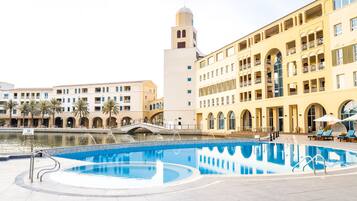 Piscine extérieure, parasols de plage, chaises longues