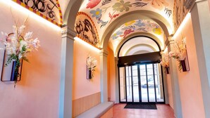 An interior hallway with floral ceiling art, arched ceilings, and wall-mounted flower arrangements. - ibis Styles Strasbourg Centre République (Strasbourg)