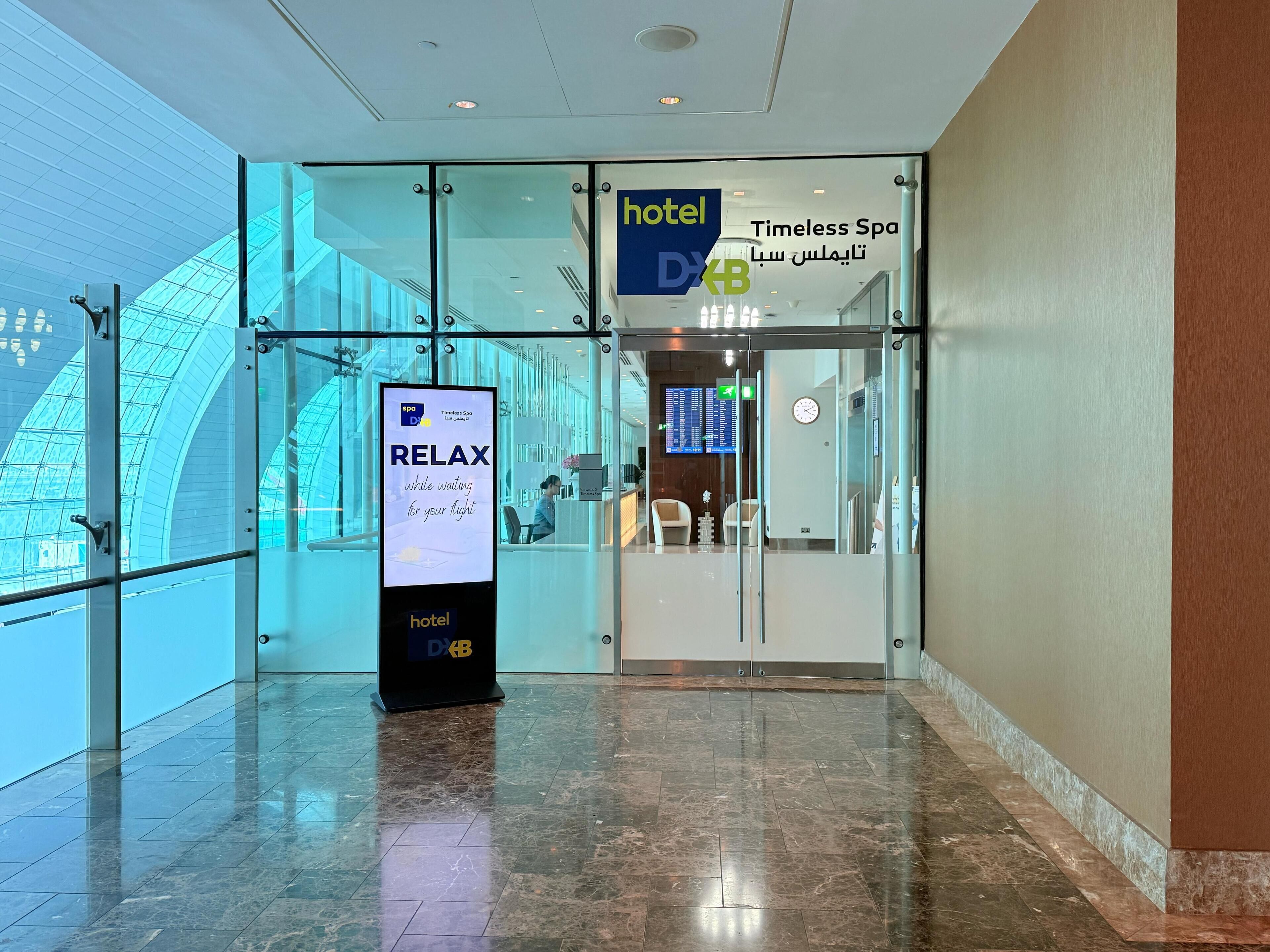 A hotel entrance with a digital signboard advertising a spa.