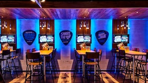 A restaurant with wooden ceiling and walls, illuminated by blue lighting. There are tables and chairs arranged for dining. - St Christopher's Village, London Bridge - Hostel (London)