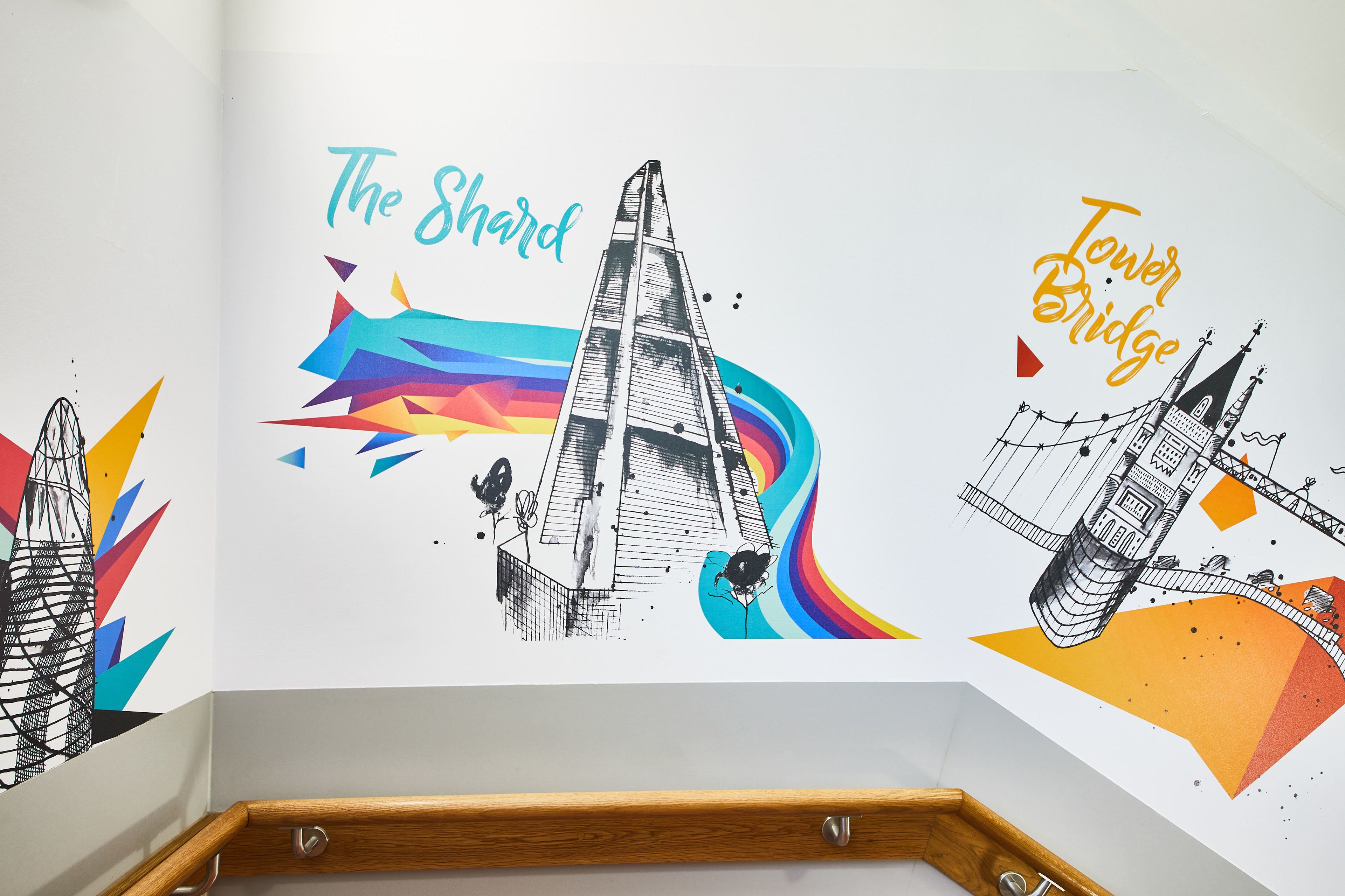 A wall with architectural illustrations of The Shard and Tower Bridge.