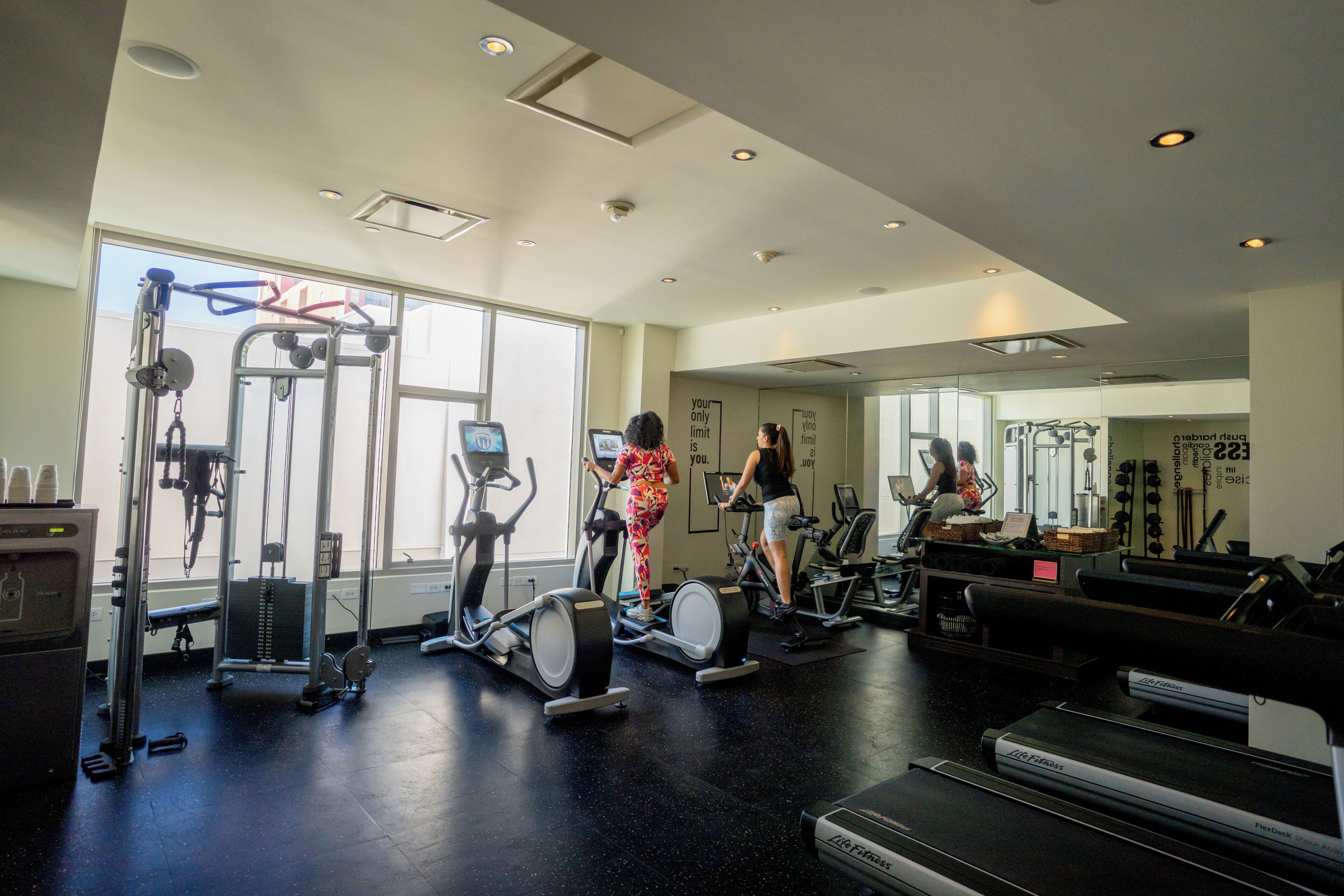 A gym with treadmills, elliptical machines, and weight equipment.