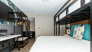 A compact hotel room with a bunk bed, a desk with a laptop, and a small seating area. - Magnolia Tree Hotel - Near Anaheim Convention Center (Anaheim)
