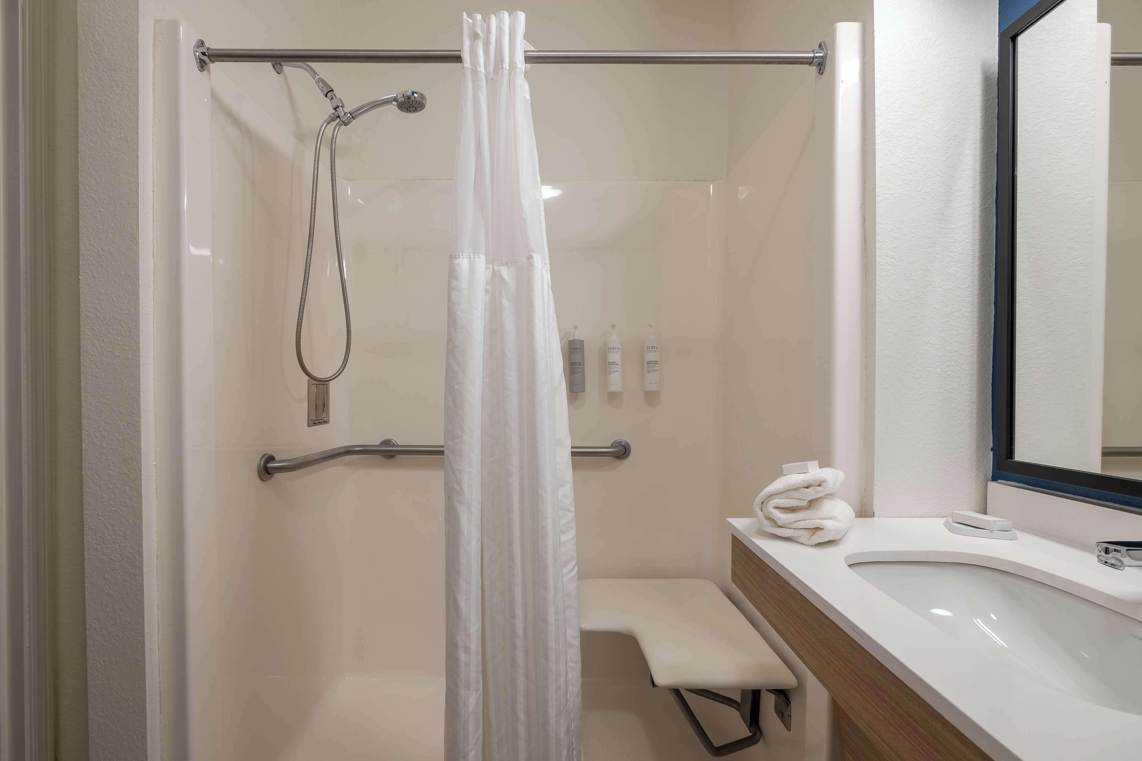 A modern bathroom with a shower, a toilet, and a sink.
