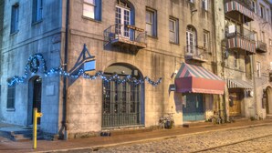 Un bâtiment historique doté d’une façade en pierre, de nombreuses fenêtres et d’un petit auvent.
