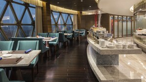 A modern restaurant with a high ceiling, large windows, and a central buffet area. - Howard Johnson Pearl Plaza Wuhan (Wuhan)