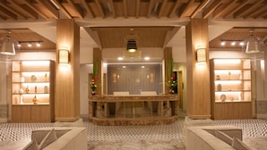 A modern lobby with a central reception desk, patterned floor, and wooden accents. - ACCESS Resort & Villas (Karon)