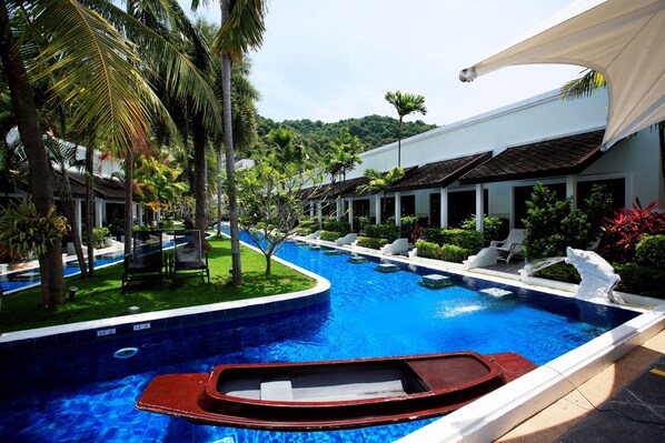 A swimming pool with a boat, palm trees, and lounge chairs. - ACCESS Resort & Villas (Karon)