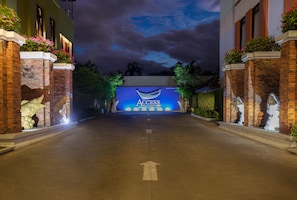 L’entrée d’un hôtel, avec une grande enseigne lumineuse indiquant « ACCESS RESORT & MALLAS » et un chemin clairement balisé par des flèches directionnelles.