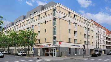Un hotel de varios pisos con fachada moderna, situado en una esquina.