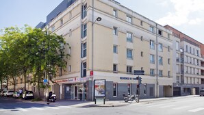 Een meerlaags hotel met een bordje met daarop 'Residence de Tour' en een zichtbare ingang.