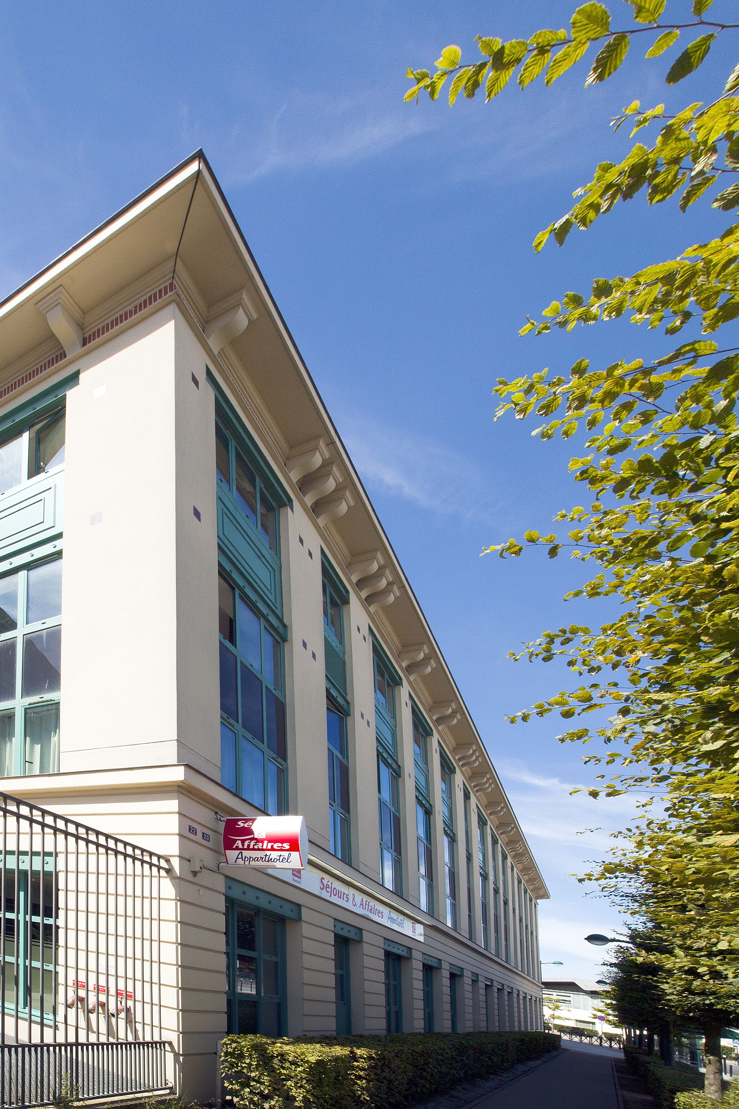 Un immeuble avec une enseigne indiquant « Séjours & Affaires » et « Appartement ».
