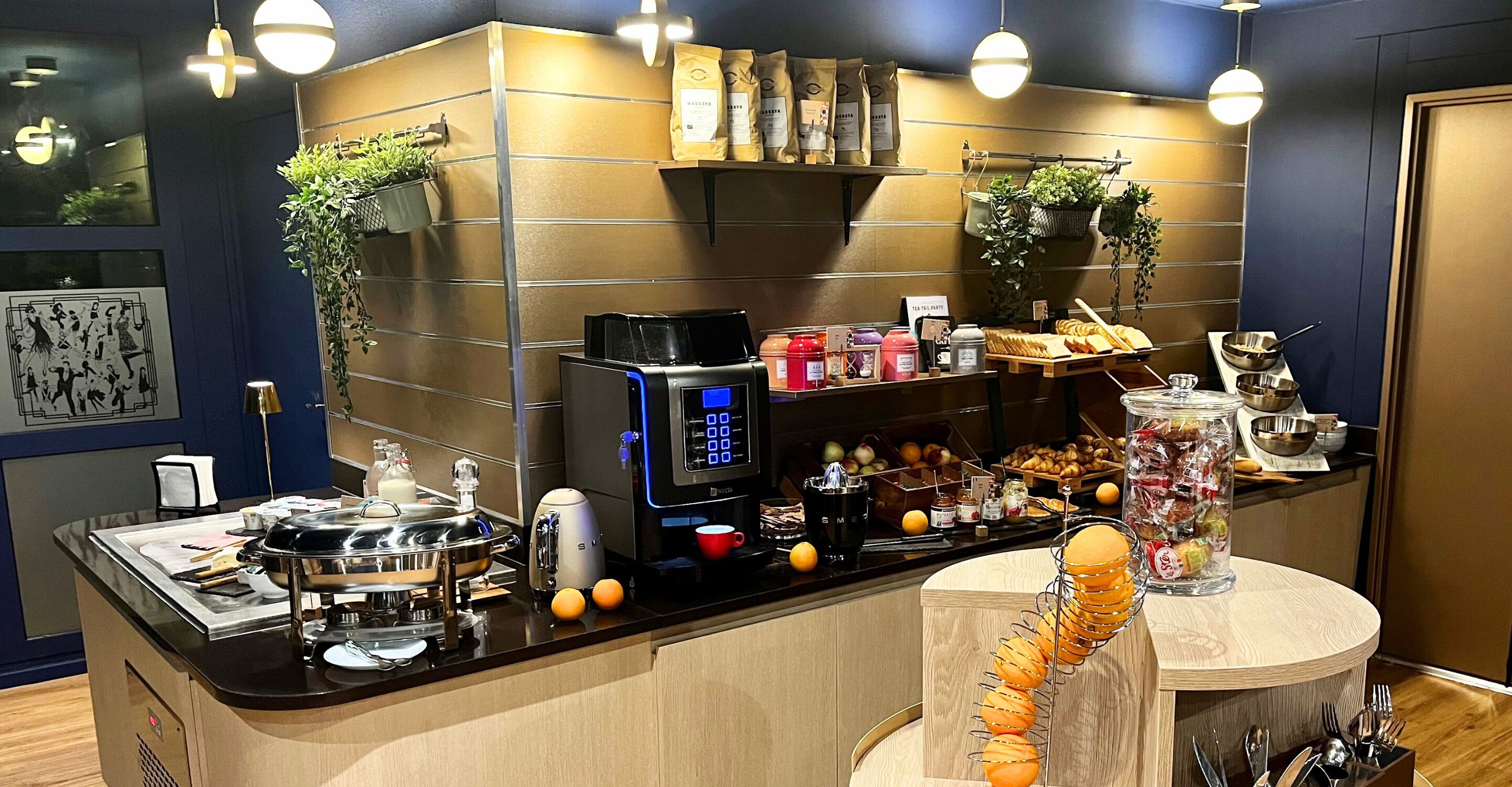 Ein Frühstücksbuffet mit Kaffeemaschine, Obst und Beilagen.