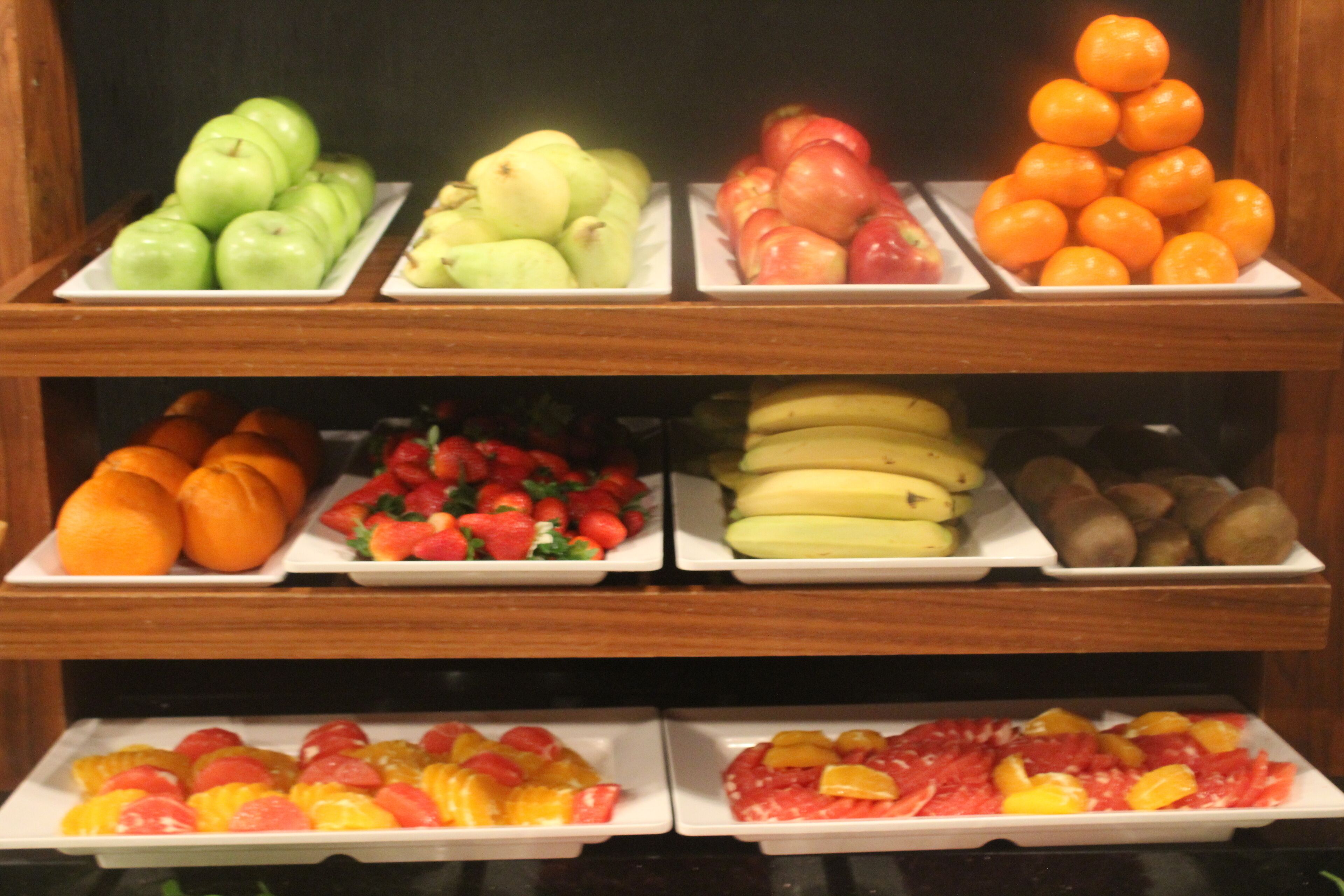 Une présentation de fruits comprenant différents types de fruits disposés sur des assiettes.