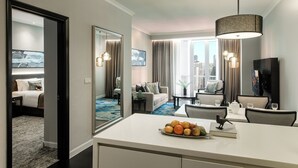 Habitació d'hotel moderna amb zona de menjador, espai saló i finestra gran amb vista a la ciutat.