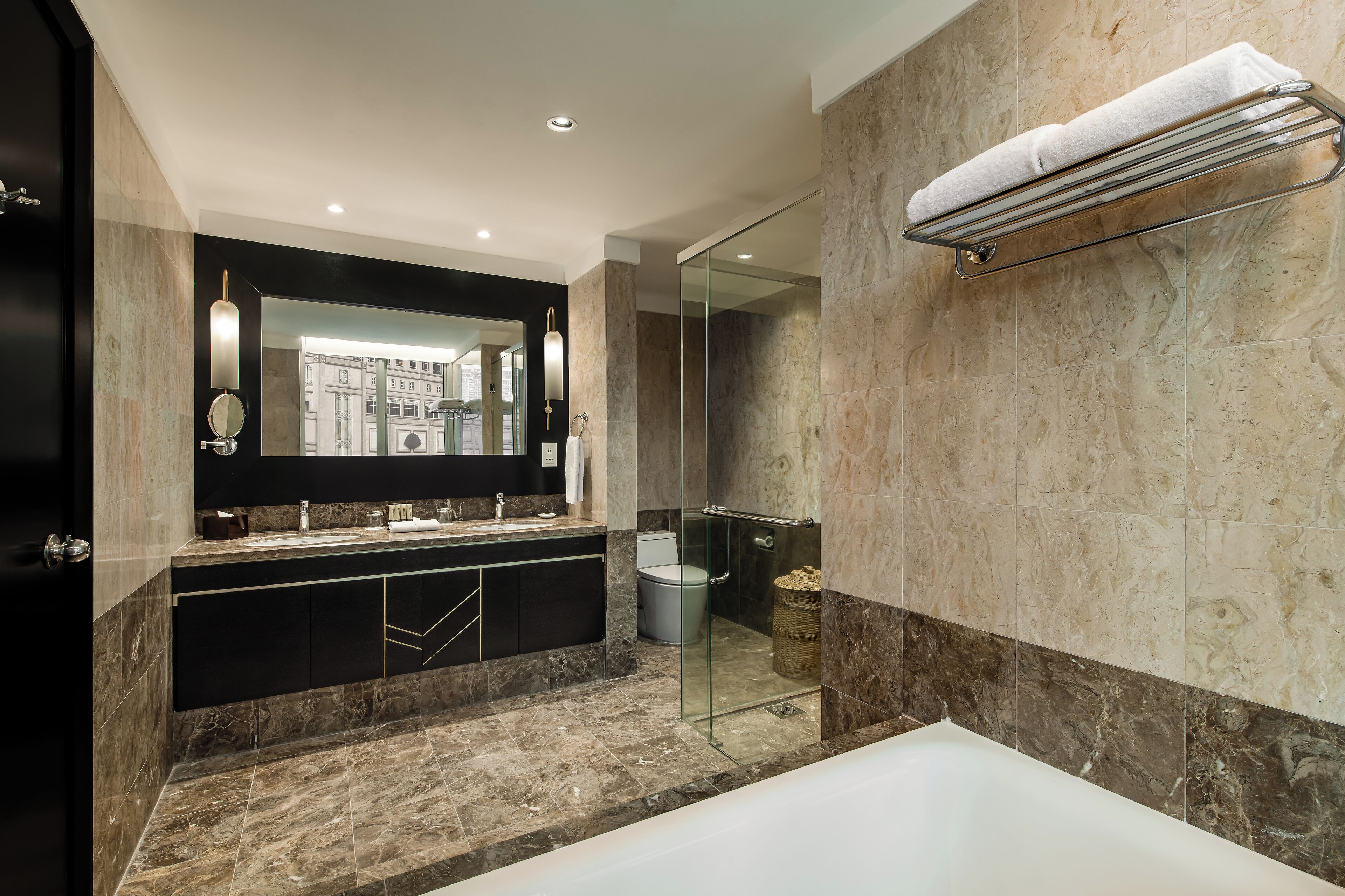 Een moderne badkamer met een douche met glazen wand, een grote spiegel en een inbouw handdoekhouder.