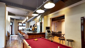 A pool table with stools, a bar area, and a seating area with tables and chairs. - Hotel Sophia (Melbourne)