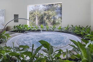 Una piscina cubierta, una piscina al aire libre, sombrillas, tumbonas