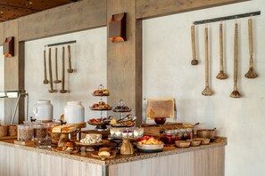 A buffet setup with various food items and utensils.