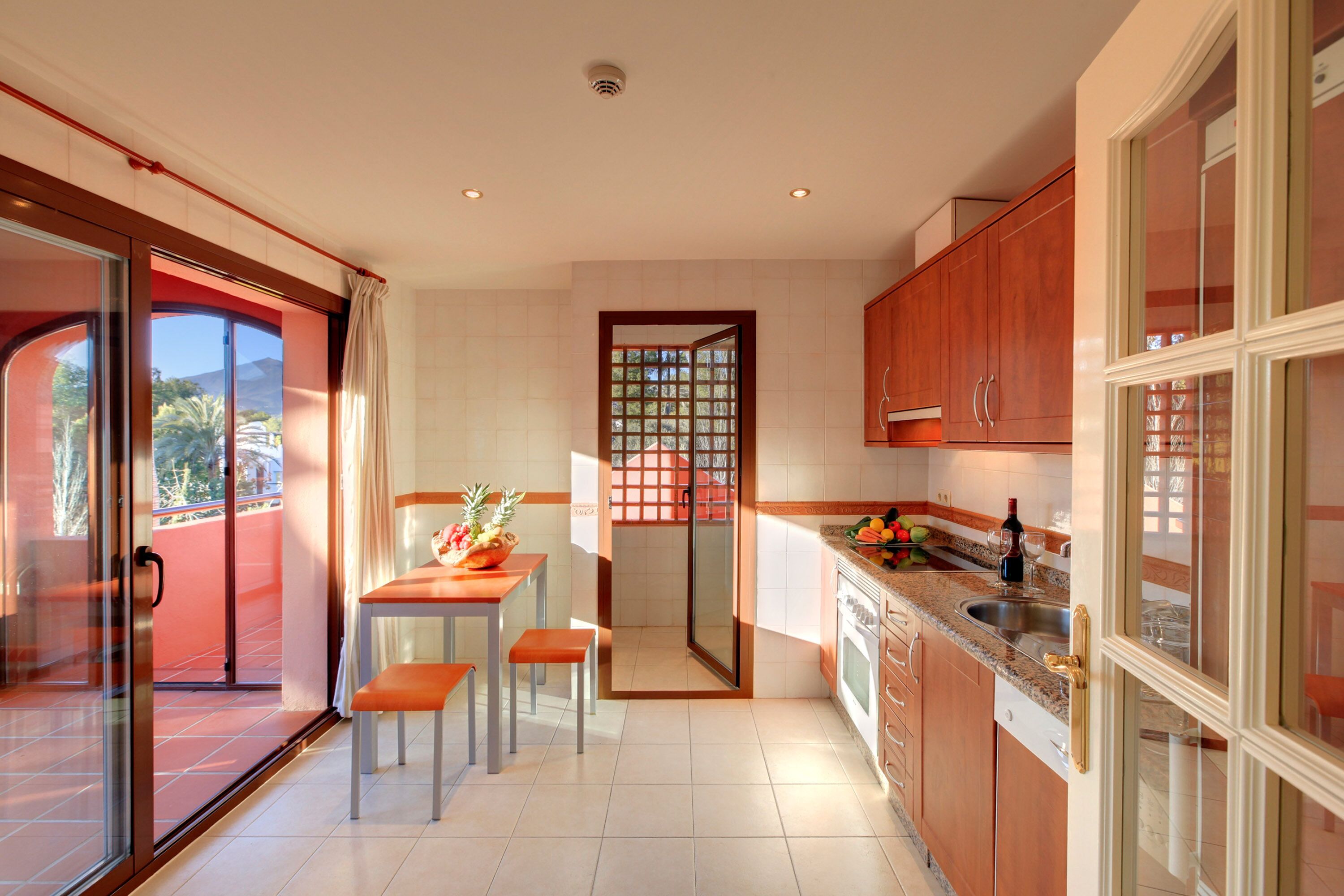 Una cocina con comedor, una puerta corrediza de vidrio que da a un espacio exterior y vistas al exterior.