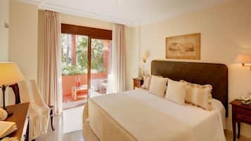 Una habitación de hotel con una cama grande, una silla, un escritorio y una ventana con cortinas.