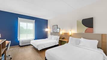 Habitación de hotel con dos camas, un escritorio, una silla, un ventanal y luces fijadas a la pared.