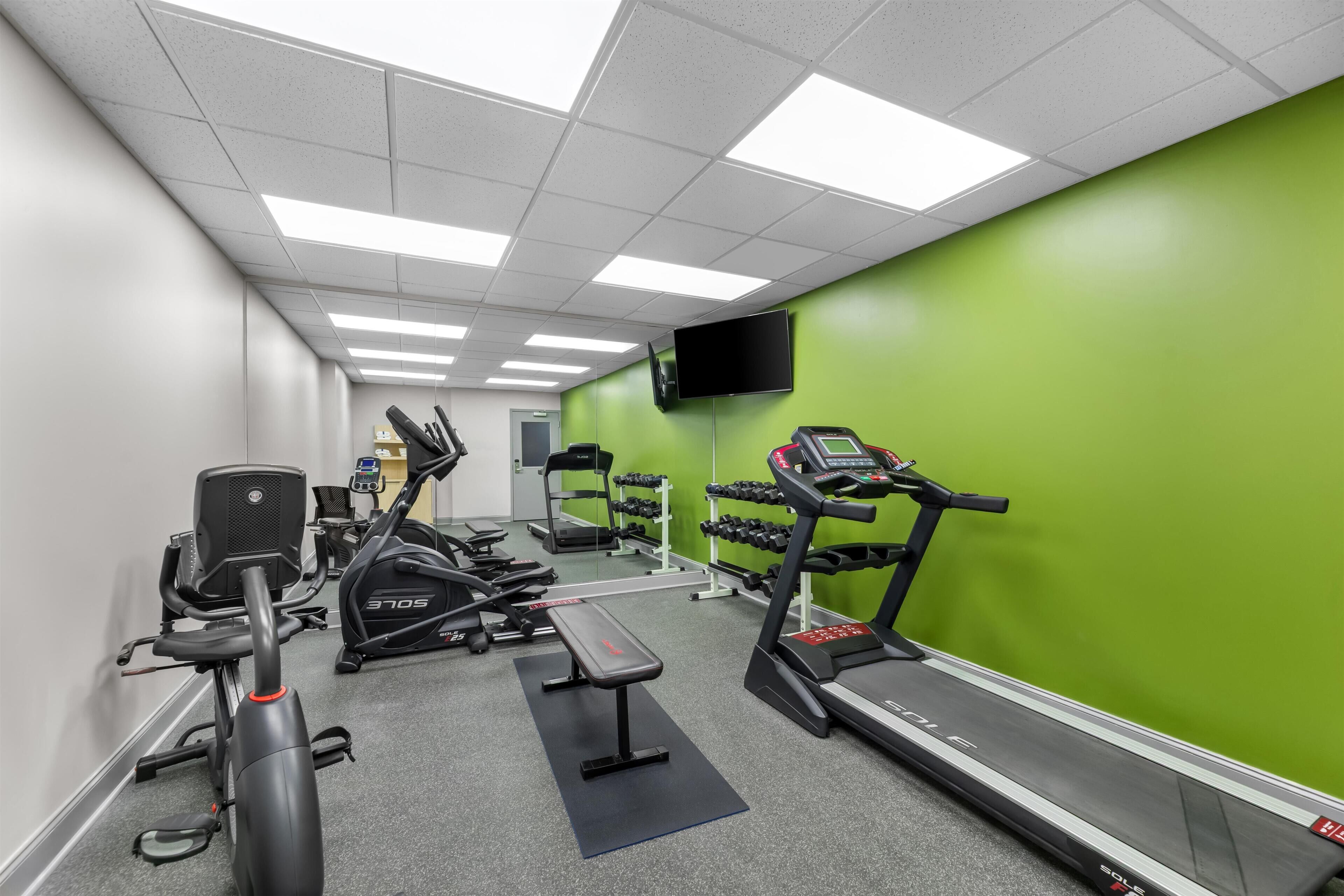 A gym with treadmills, stationary bikes, and weight machines.