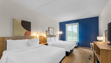Habitación de hotel con dos camas, lámparas de noche, un escritorio y un ventanal grande.