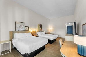 A hotel room with two beds, bedside tables, a desk, a chair, a TV, and wall-mounted lights. - Spark by Hilton Tuscumbia Muscle Shoals (Tuscumbia)