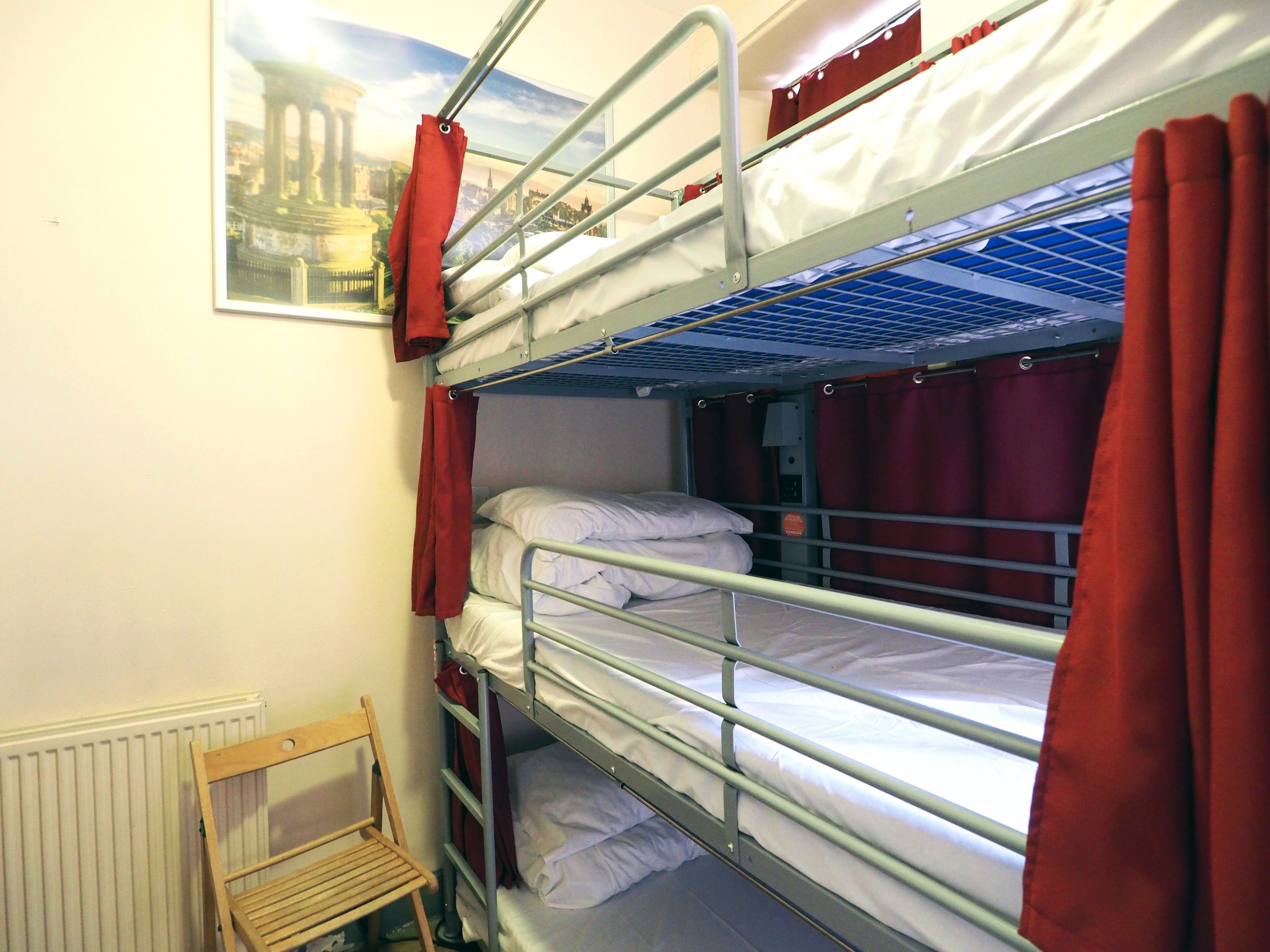 A bunk bed room with a wooden chair and a radiator.