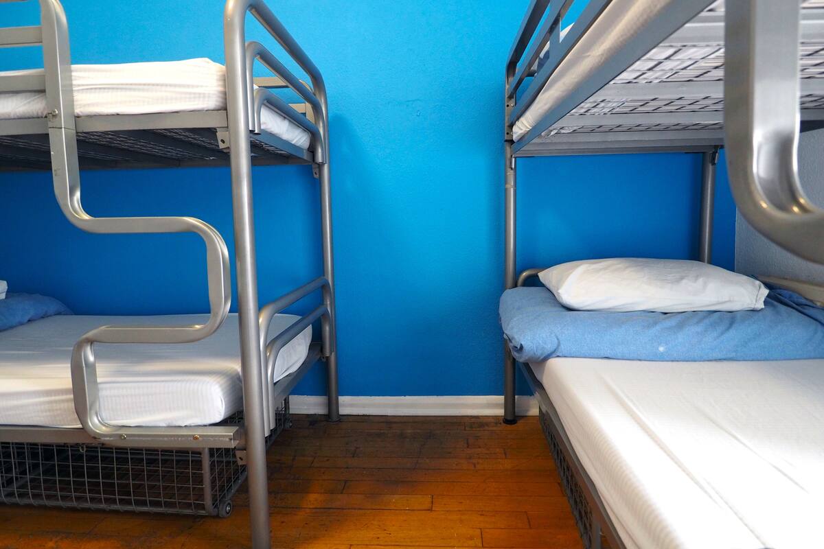 A bunk bed room with blue walls and wooden flooring.