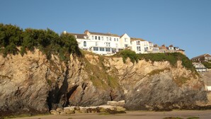 A coastal building with multiple stories, situated on a cliff overlooking the beach. - St Christopher's Inn, Newquay - Hostel (Newquay)