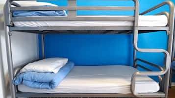 Un lit superposé à deux niveaux, chaque niveau étant équipé d’un matelas et d’oreillers.