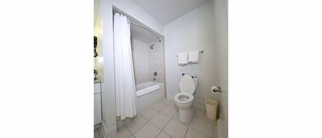 Un baño con bañera, inodoro y zona de ducha.
