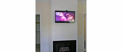Una sala de estar con televisor de pantalla plana sobre la chimenea.