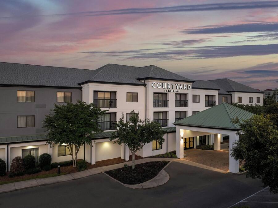 A Courtyard by Marriott hotel with a modern design, featuring a covered entrance and a landscaped driveway.
