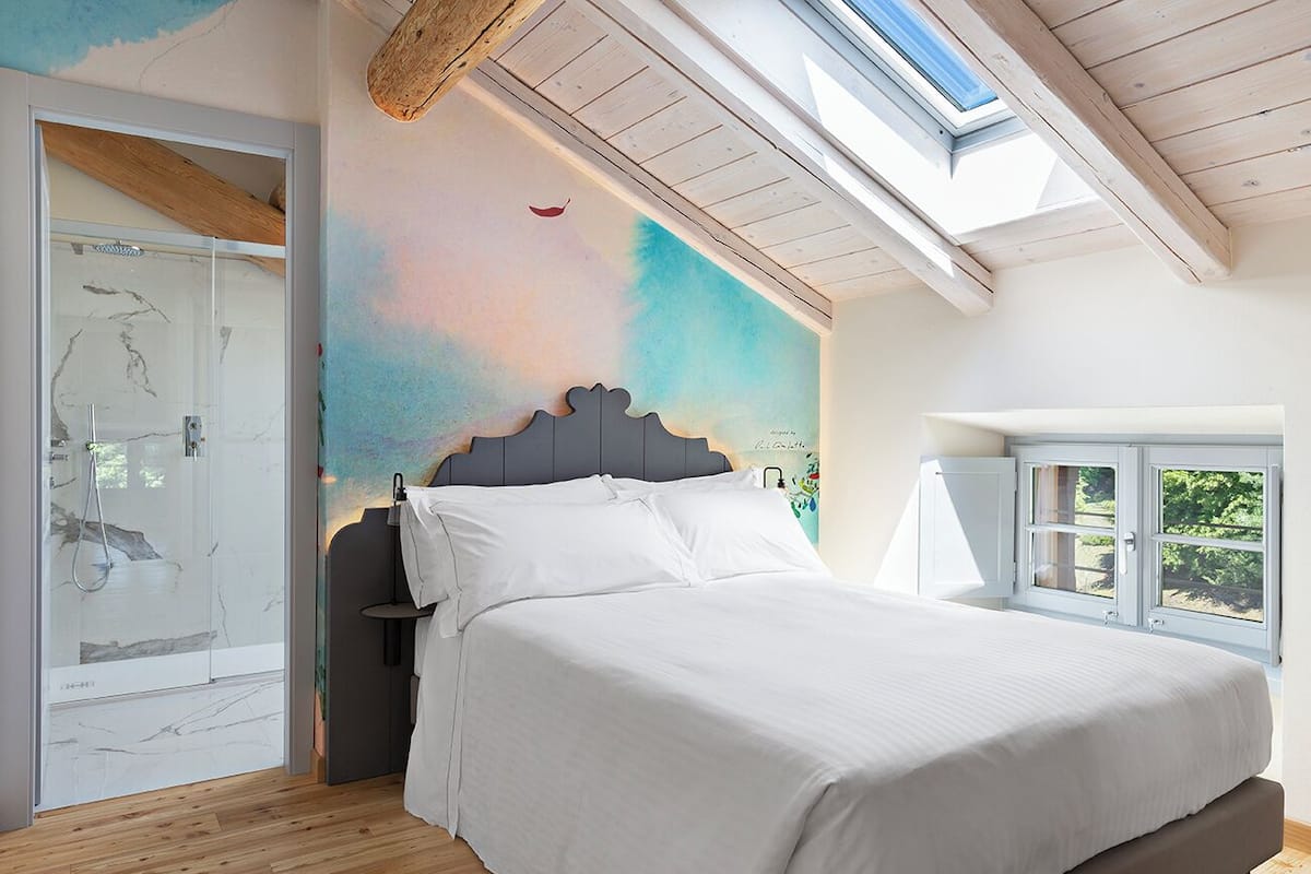 Ein Schlafzimmer mit Bett, Oberlicht, Fenster und Tür.